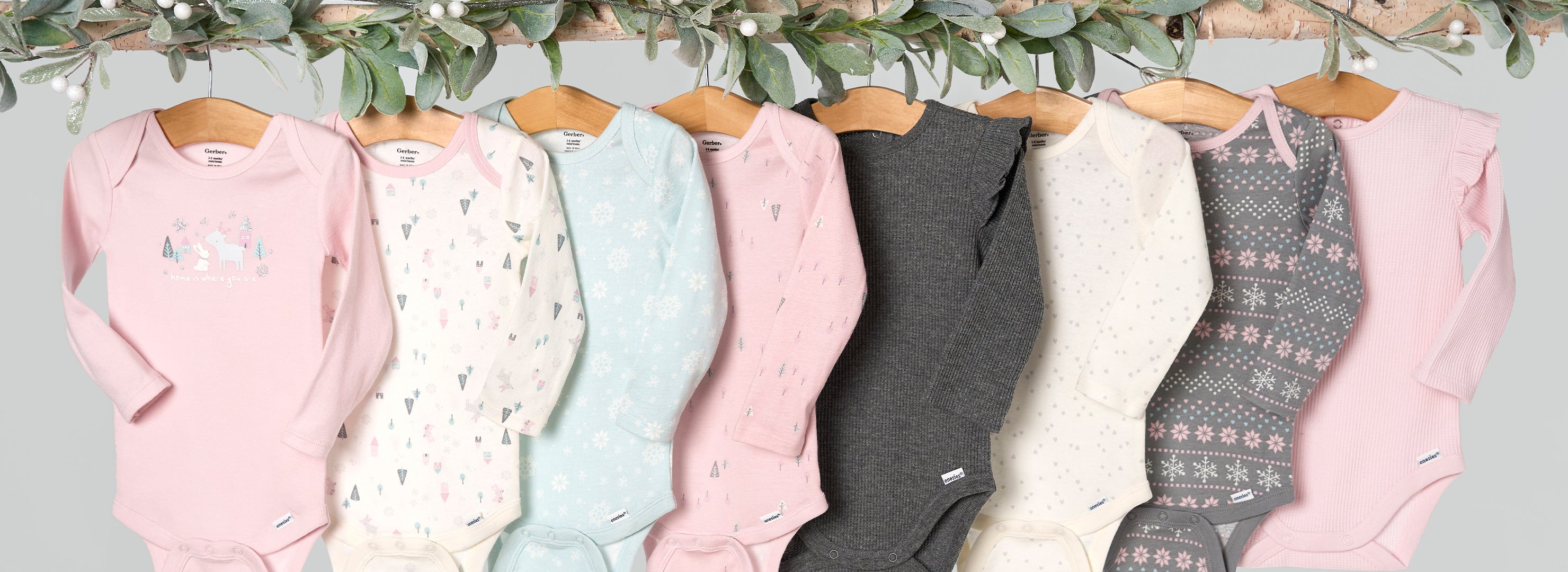 A whimsical sight: adorable winter girls' baby clothes hanging on a tree, creating a colorful display of tiny outfits in nature's wardrobe.