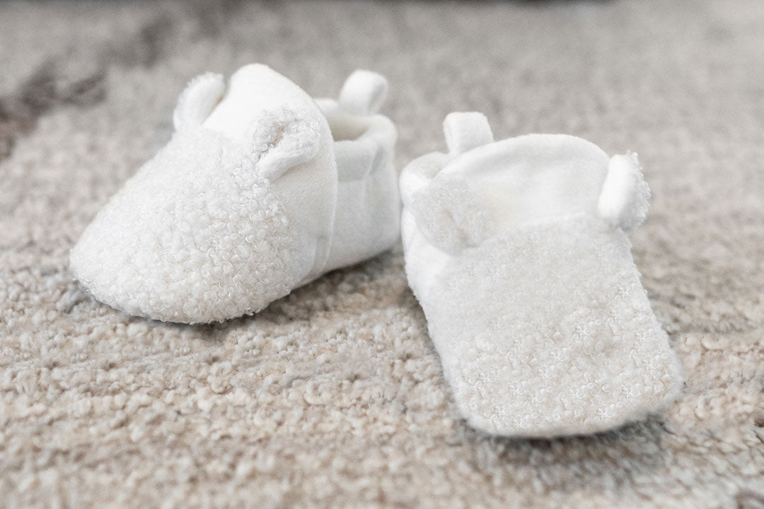 Cute white fuzzy baby shoes featuring soft fur on top, ideal for little ones to stay cozy and fashionable