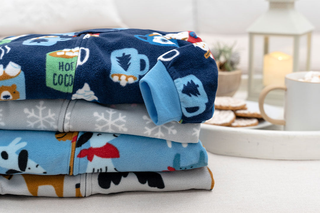 A delightful assortment of cozy pajamas adorned with adorable dogs and snowmen, neatly stacked and ready for winter nights